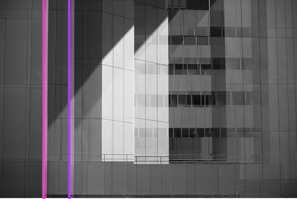 Architectural photo of a glass building with two pink and purple lines running vertically through it.
